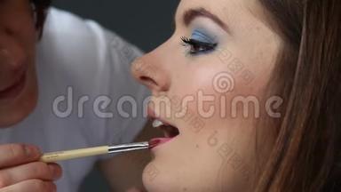 化妆师将唇彩涂于模特唇上，全高清